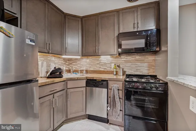 a kitchen with granite countertop cabinets stainless steel appliances and a counter space
