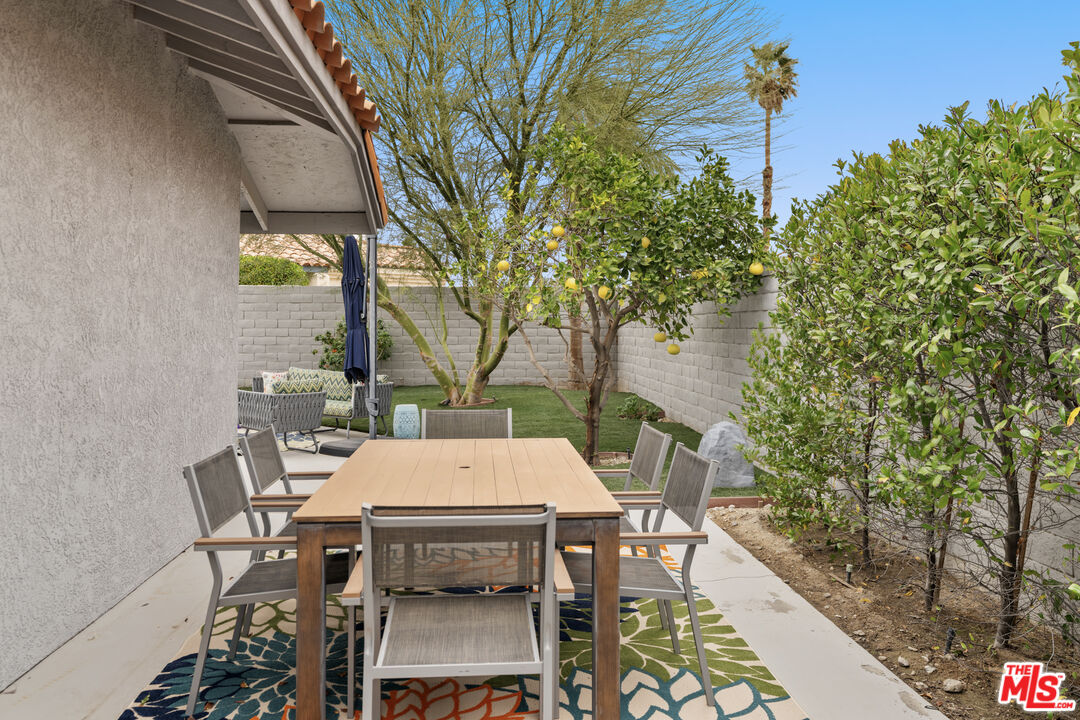 1450 East Racquet Club Road Palm Springs, CA 92262 - Photo 23 of 31 a view of a patio with table and chairs and potted plants