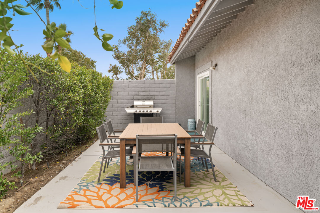 1450 East Racquet Club Road Palm Springs, CA 92262 - Photo 24 of 31 a patio with table and chairs and potted plants