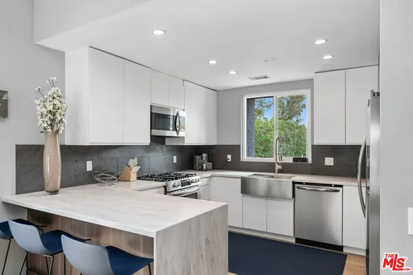 a kitchen with a sink a stove a microwave and cabinets