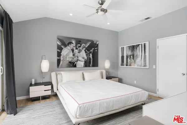 a bedroom with a bed and a painting on the wall