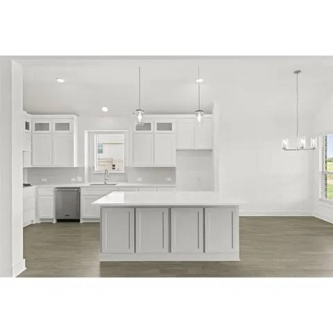 a kitchen with stainless steel appliances granite countertop a stove a sink and white cabinets