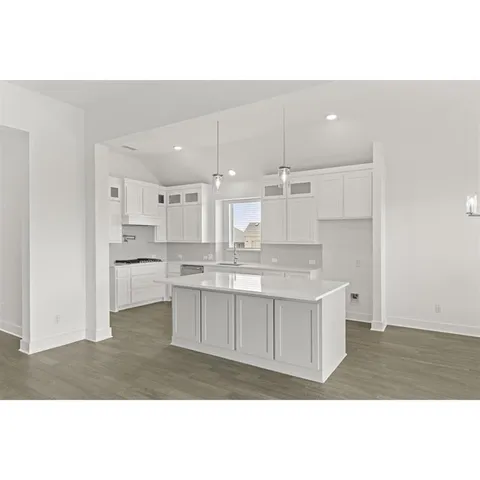 a kitchen with white cabinets and window