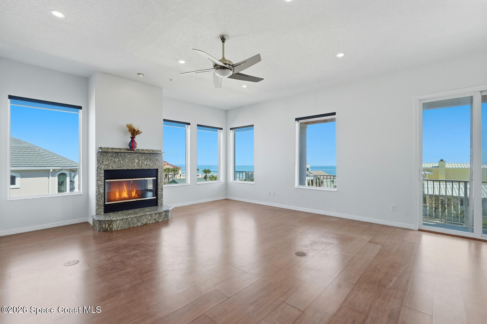 4688 South Atlantic Avenue Ponce Inlet, FL 32127 - Photo 13 of 83 a view of an empty room with wooden floor fireplace and a window