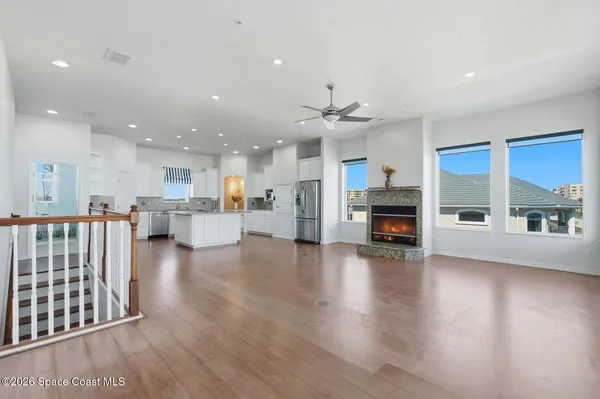 a view of a livingroom with wooden floor and a ceiling fan