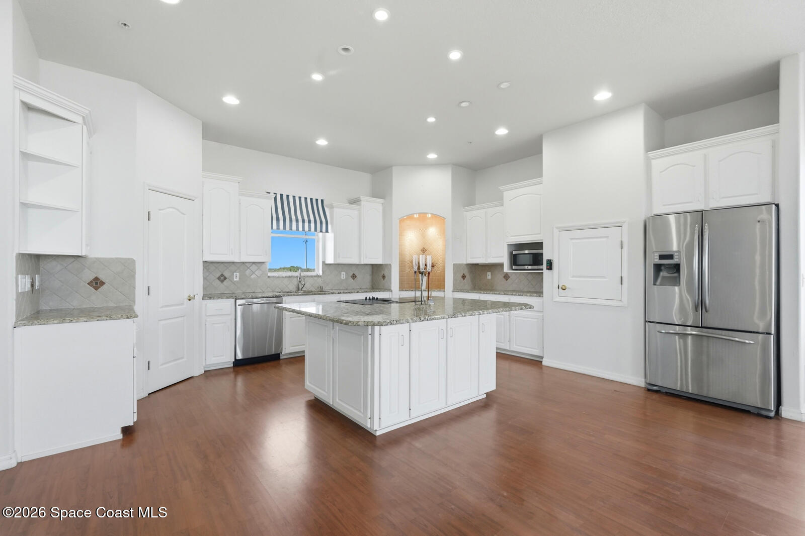 4688 South Atlantic Avenue Ponce Inlet, FL 32127 - Photo 17 of 83 a kitchen with white cabinets and stainless steel appliances