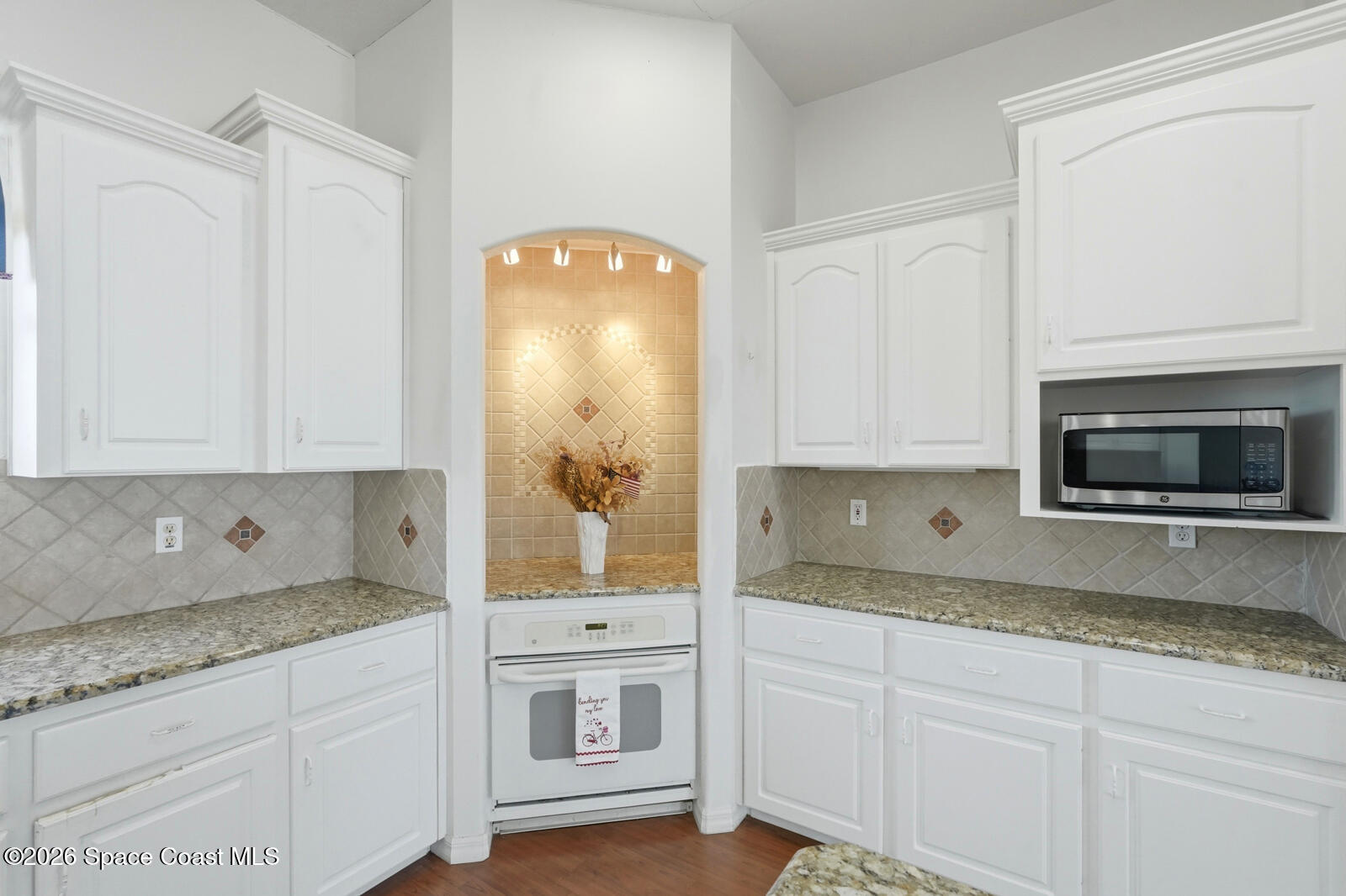 4688 South Atlantic Avenue Ponce Inlet, FL 32127 - Photo 20 of 83 a kitchen with granite countertop white cabinets and stainless steel appliances