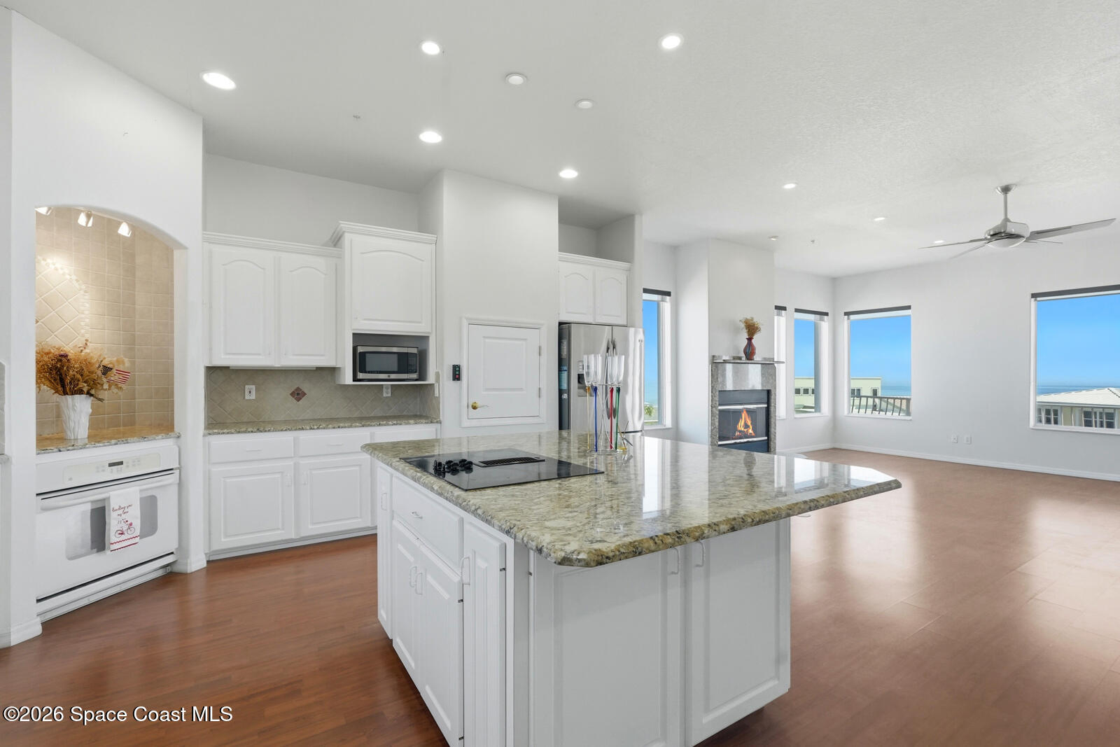 4688 South Atlantic Avenue Ponce Inlet, FL 32127 - Photo 21 of 83 a kitchen with stainless steel appliances granite countertop a sink a stove a refrigerator and white cabinets with wooden floor