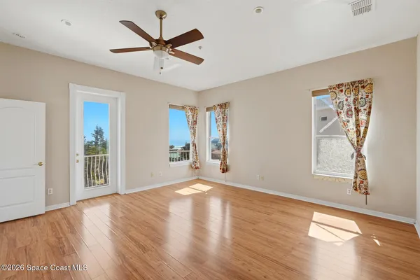 an empty room with windows and fan
