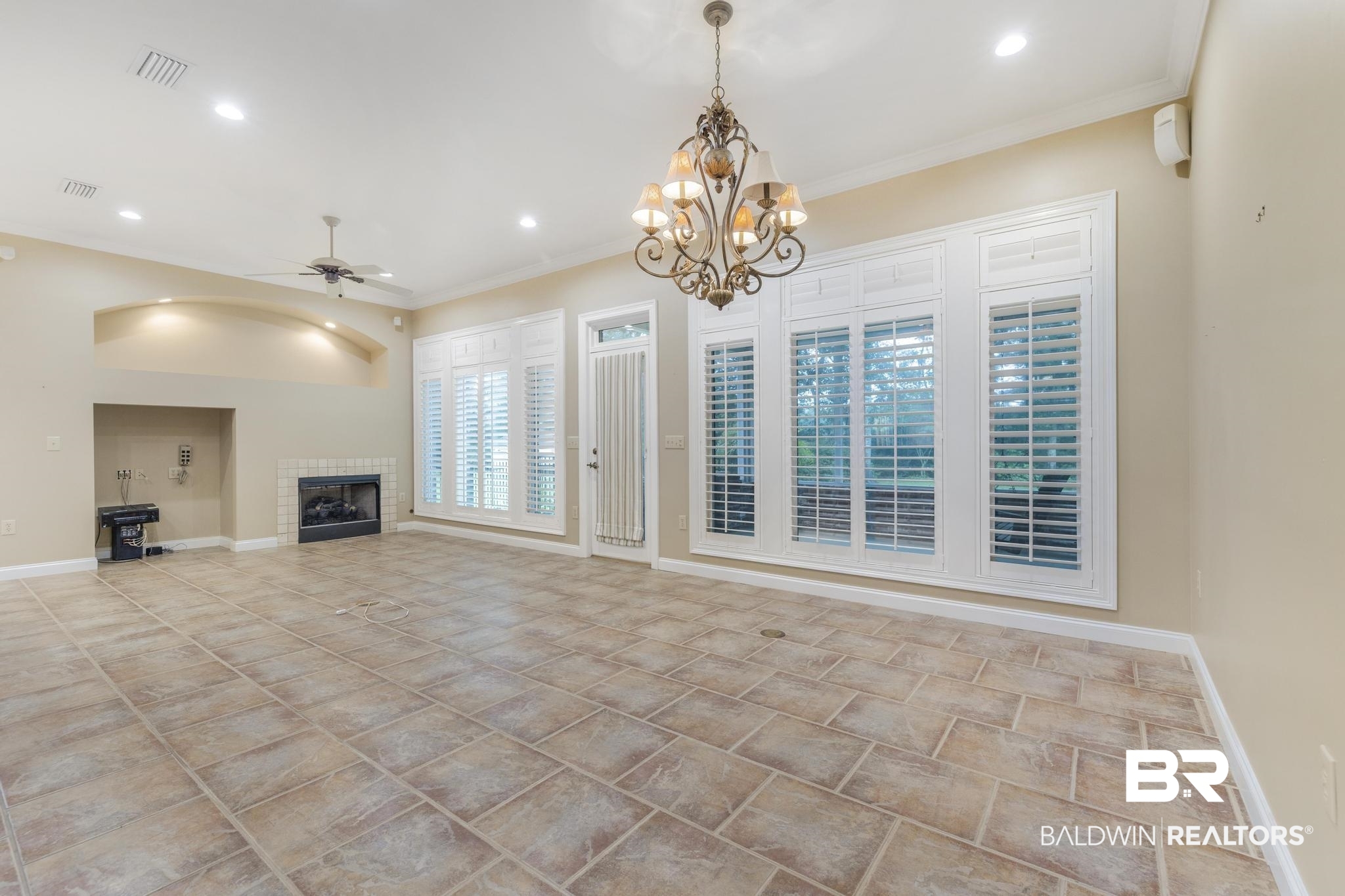 13612 Rue Royal Lane Silverhill, AL 36576 - Photo 11 of 65 Unfurnished living room featuring ornamental molding, a fireplace, a ceiling fan, recessed lighting, and a chandelier
