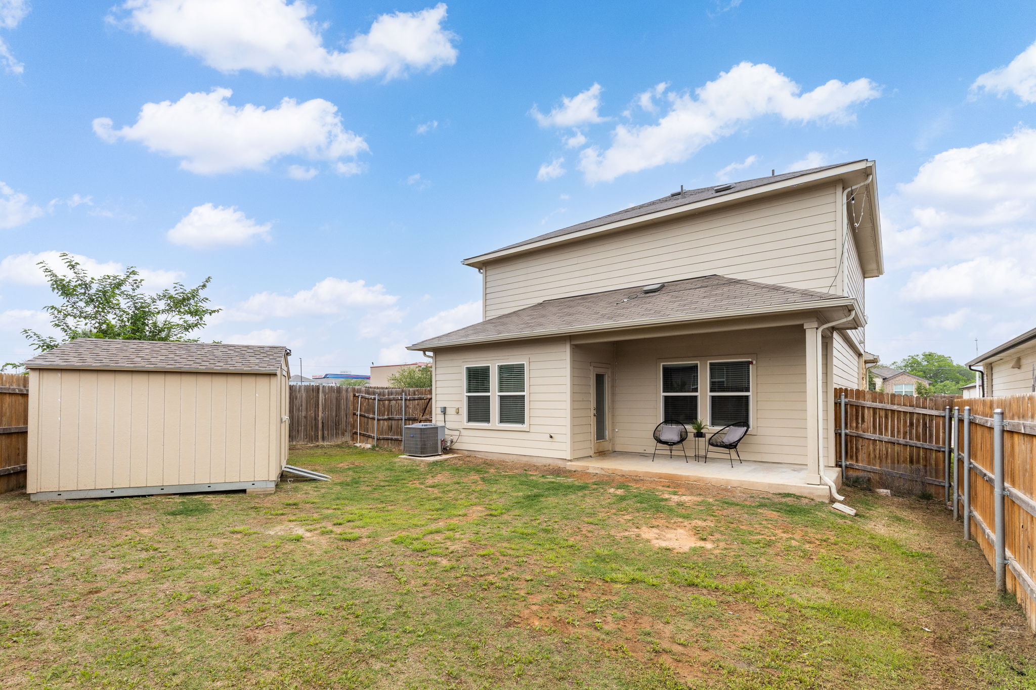 281 Jayden Drive Kyle, TX 78640 - Photo 31 of 36 Expansive backyard featuring a covered patio, a detached storage shed, wood privacy fencing, and exterior siding
