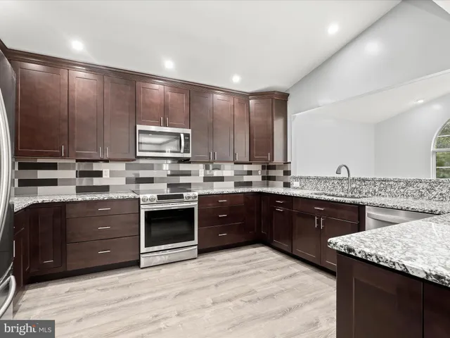 a kitchen with stainless steel appliances granite countertop a stove a sink dishwasher and a refrigerator