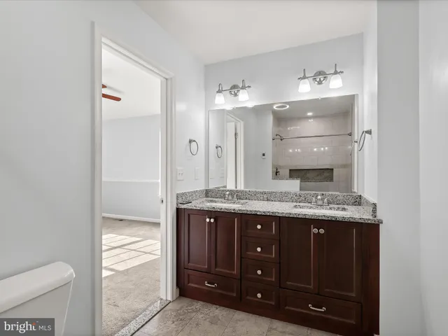 a bathroom with a granite countertop sink and a mirror