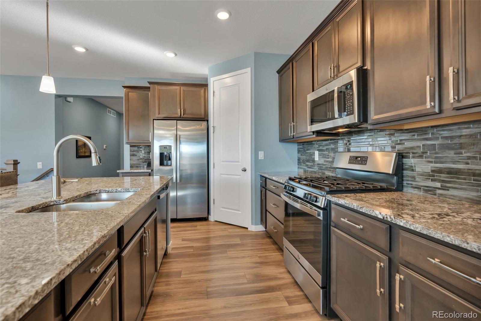 1122 Highpoint Trail Elizabeth, CO 80107 - Photo 17 of 45 a kitchen with stainless steel appliances granite countertop a sink stove and refrigerator