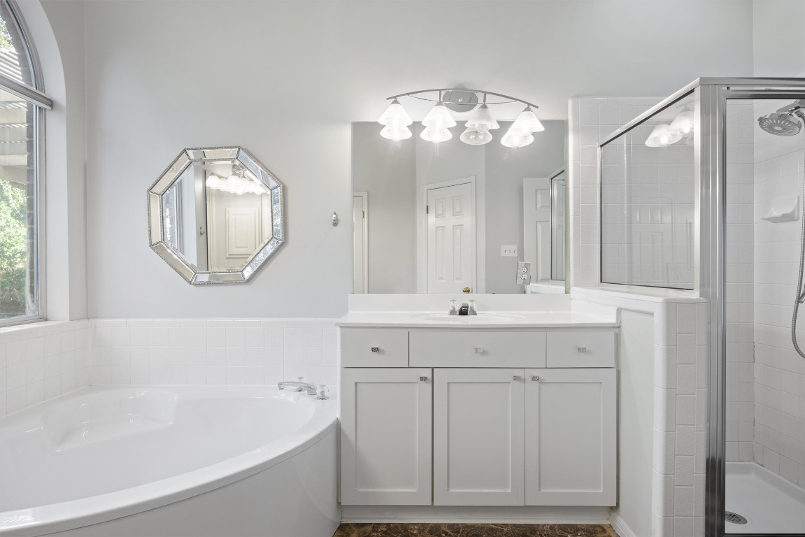 7124 Quimper Lane Austin, TX 78749 - Photo 20 of 40 a bathroom with a sink mirror and a bathtub with a mirror