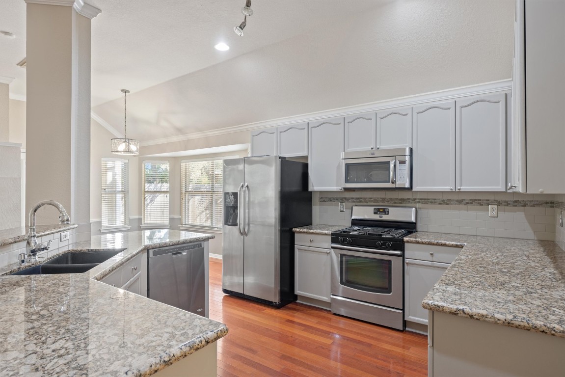 7124 Quimper Lane Austin, TX 78749 - Photo 24 of 40 a kitchen with stainless steel appliances granite countertop a sink stove and refrigerator