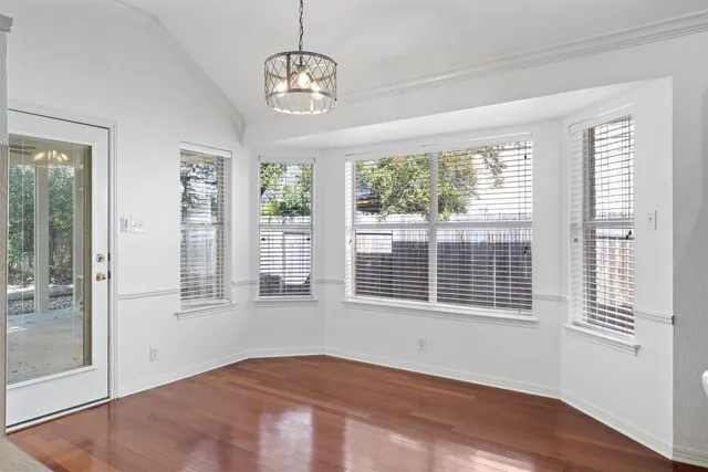 a view of a kitchen with refrigerator and wooden floor