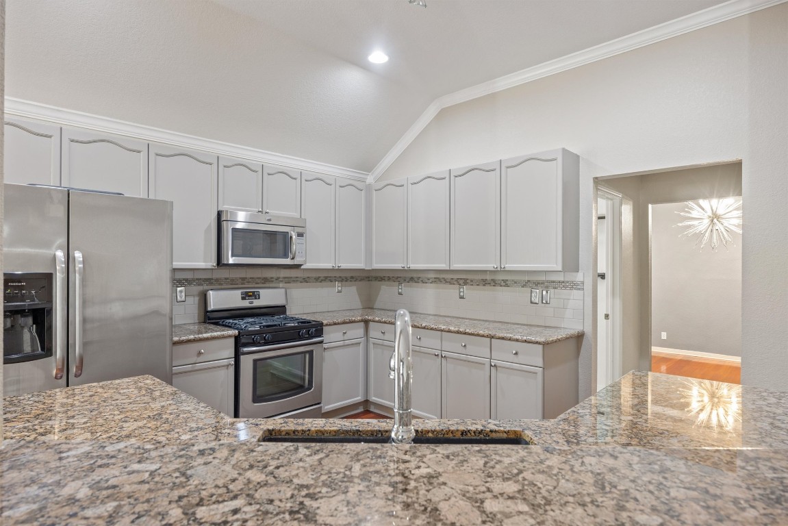 7124 Quimper Lane Austin, TX 78749 - Photo 26 of 40 a kitchen with stainless steel appliances granite countertop a stove a sink and a refrigerator