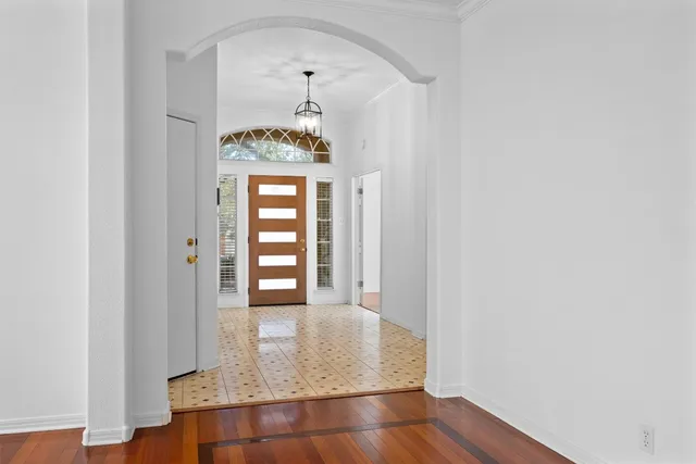 an empty room with wooden floor cabinet and windows
