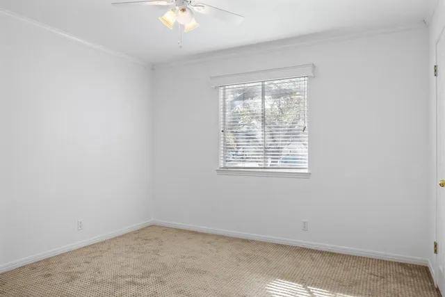 an empty room with a chandelier fan