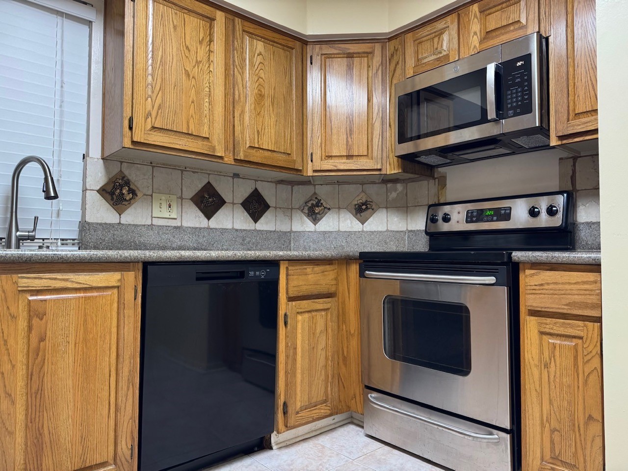 5200 Weslayan Street, Unit 311 Houston, TX 77005 - Photo 11 of 24 a kitchen with stainless steel appliances granite countertop a stove microwave and cabinets