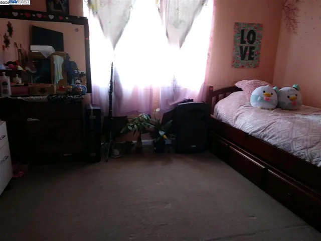 a bedroom with a bed dresser and a potted plant