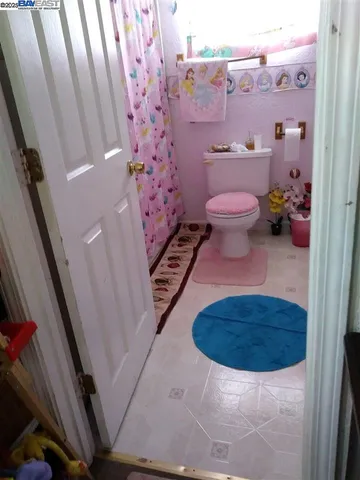 a bathroom with a toilet and a shower curtain