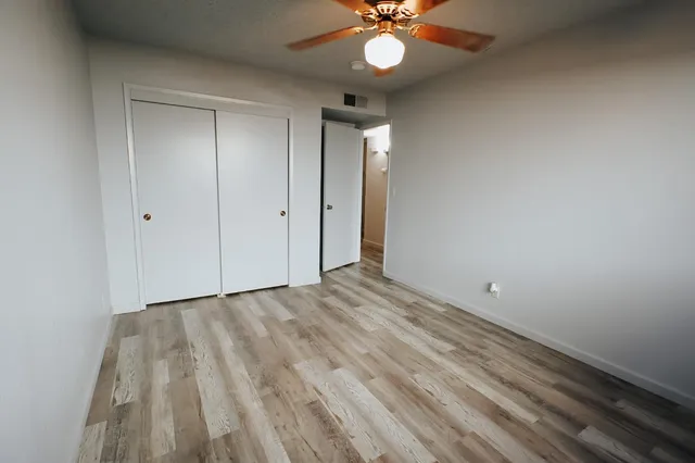 a view of an empty room and a chandelier fan