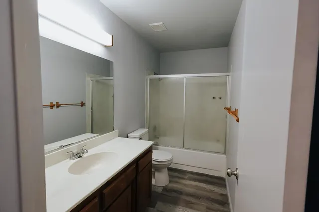 a bathroom with a sink a toilet and shower