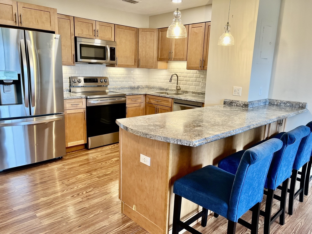 1006 Paradise Road, Unit 3R Swampscott, MA 01907 - Photo 1 of 34 a kitchen with stainless steel appliances granite countertop a kitchen island a stove a refrigerator a sink and a refrigerator