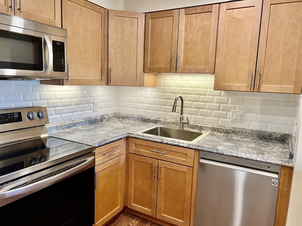 1006 Paradise Road, Unit 3R Swampscott, MA 01907 - Photo 2 of 34 a kitchen with stainless steel appliances granite countertop a sink stove and microwave