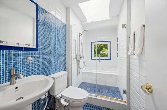 a bathroom with a sink a toilet and shower