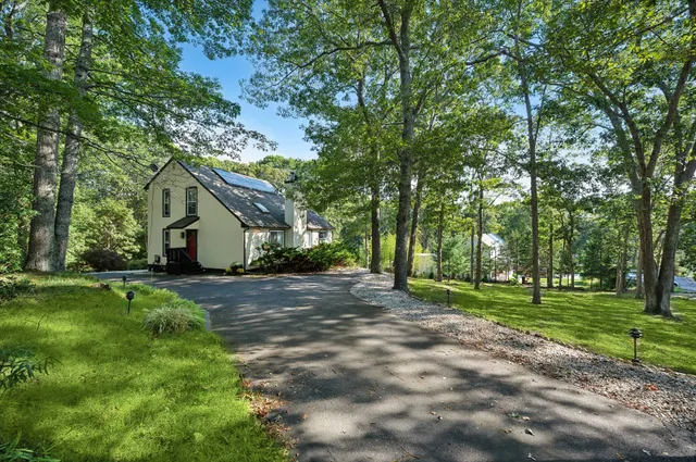 a view of a house with a big yard and large trees