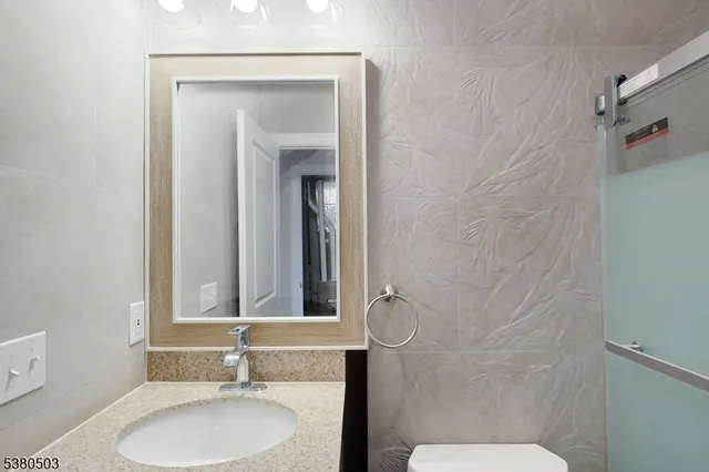 a bathroom with a sink toilet and mirror