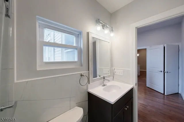 a bathroom with a sink toilet shower and a mirror