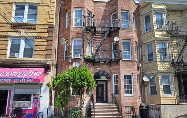 a front view of a multi story building with a yard