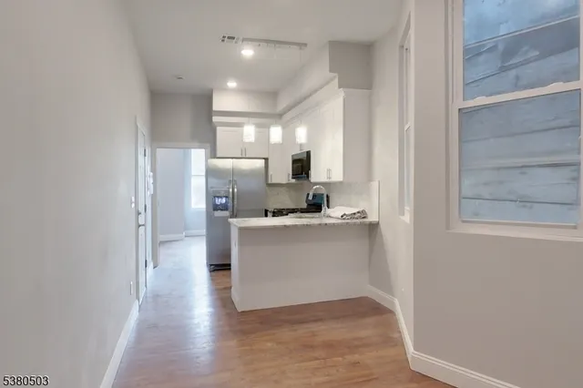 a kitchen with a refrigerator and white cabinets