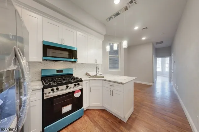 a kitchen with a stove a sink and a microwave