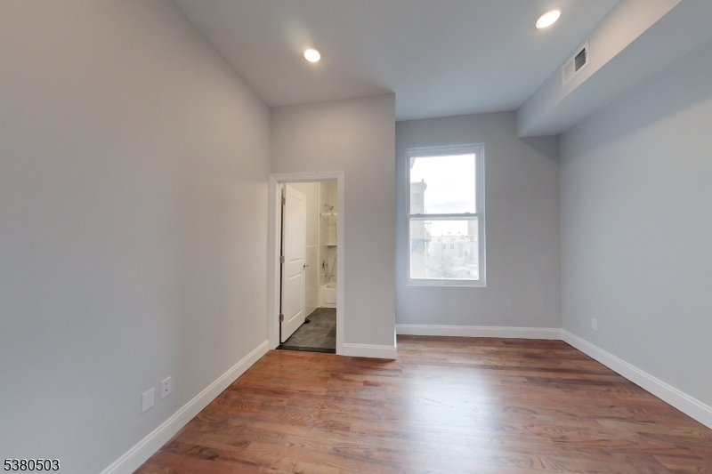 130 45th Street, Unit 4 Union City, NJ 07087 - Photo 10 of 17 an empty room with wooden floor and windows
