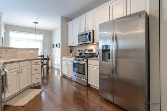 a kitchen with cabinets stainless steel appliances and a window