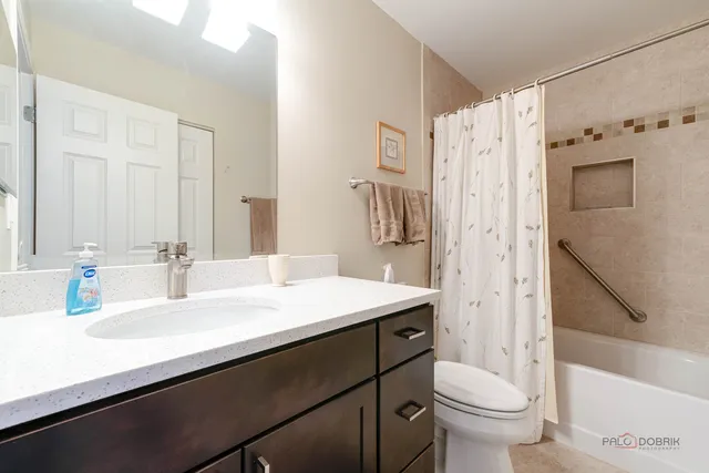 a bathroom with a sink a toilet a mirror and shower