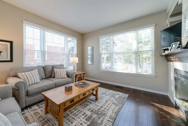 a living room with furniture a flat screen tv and a window