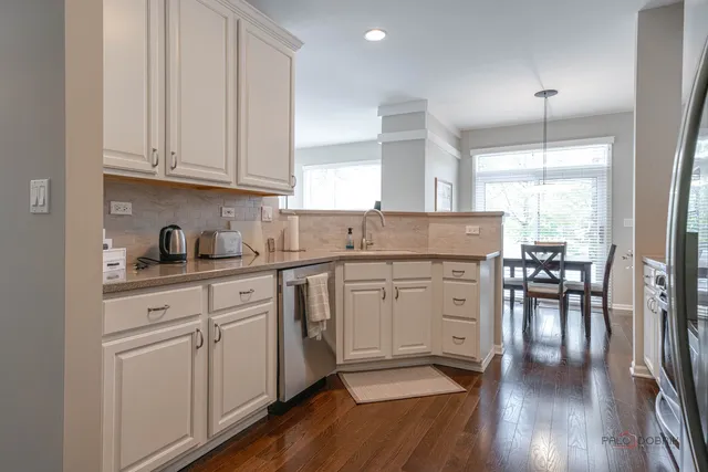 a kitchen with white cabinets and sink