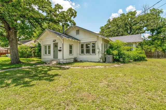 a front view of house with yard and trees around