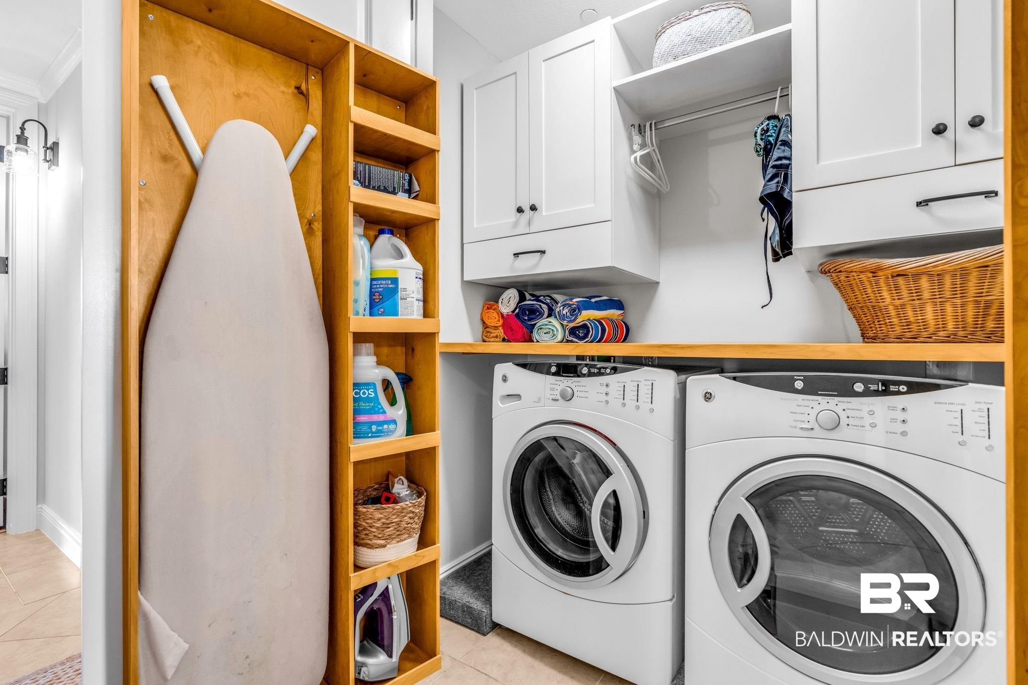 14500 River Road, Unit 305 Pensacola, FL 32507 - Photo 29 of 42 Dedicated laundry area featuring white cabinetry with dark hardware, a wood-finish countertop, and built-in shelving