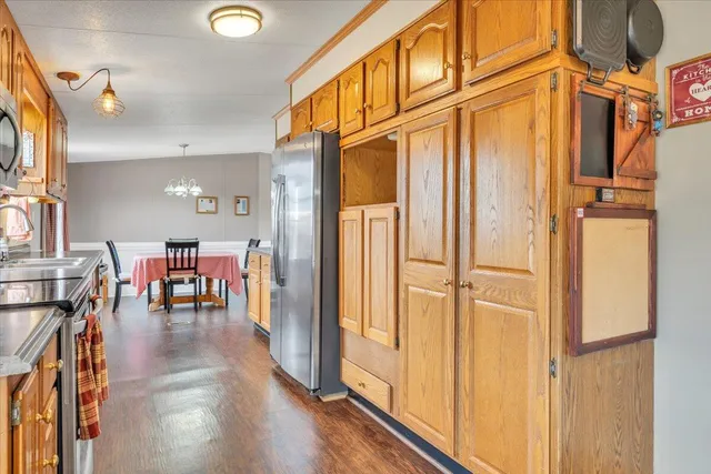 a spacious bedroom with a bed a dresser and a large window