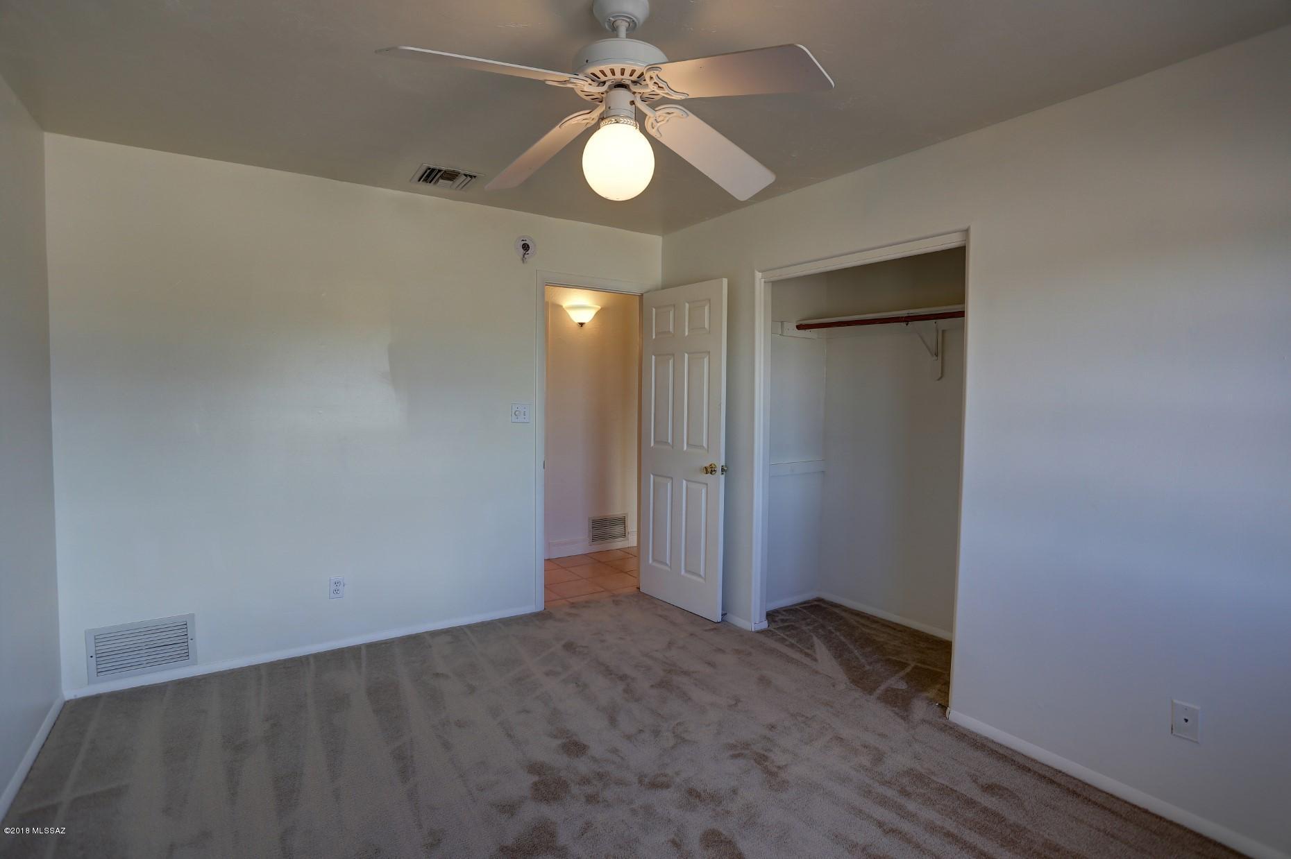 5851 South Avra Road Tucson, AZ 85735 - Photo 29 of 46 a view of an empty room and chandelier fan and fire place