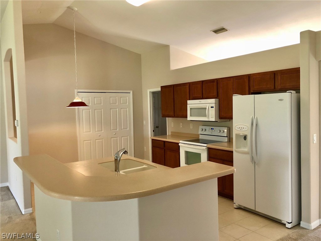 2502 Nature Pointe Loop Fort Myers, FL 33905 - Photo 3 of 5 a kitchen with stainless steel appliances a refrigerator and a stove