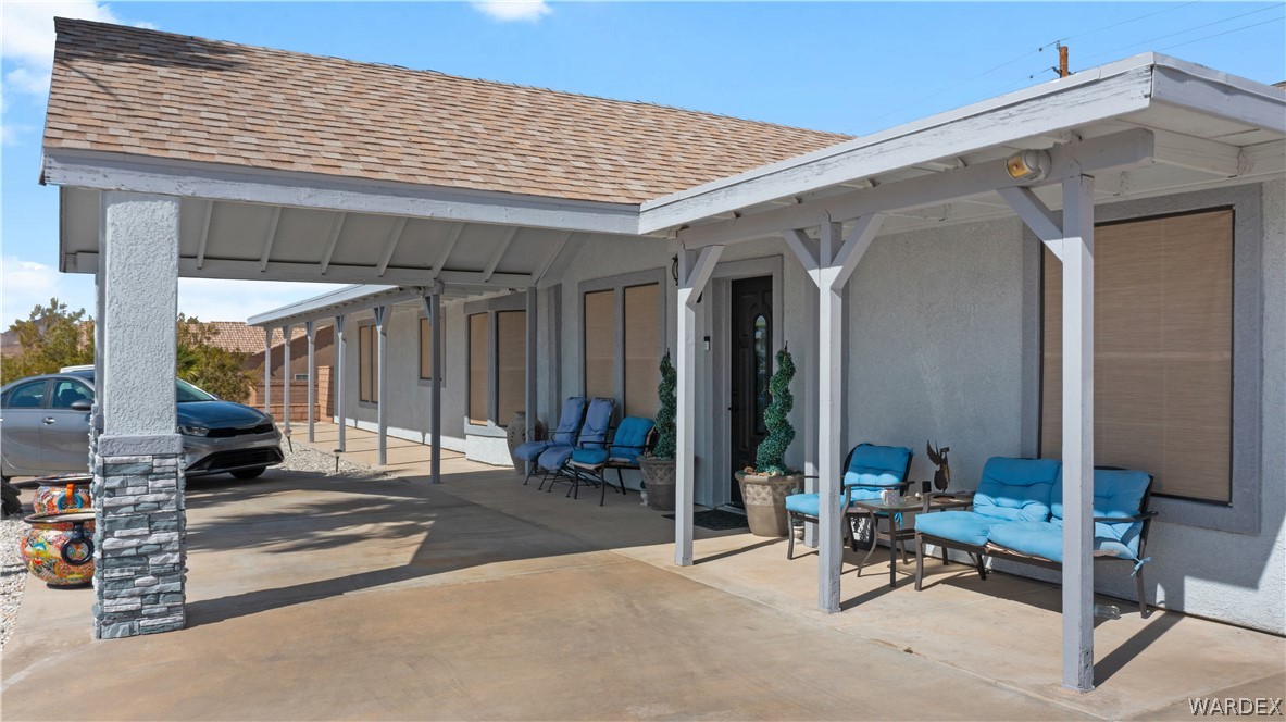 784 Pegasus Ranch Road Bullhead City, AZ 86429 - Photo 67 of 100 Exterior showcasing a covered carport with stone-clad columns and a shingle roof