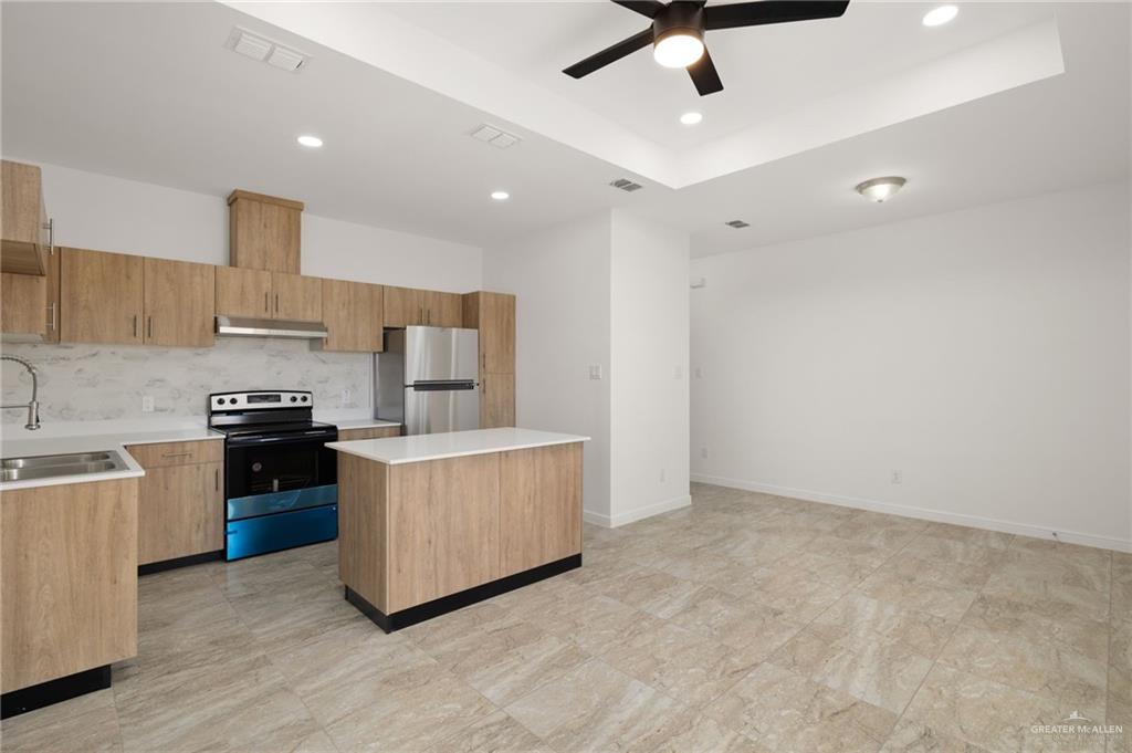 5304 Vision Street Rio Grande City, TX 78582 - Photo 13 of 26 a kitchen with kitchen island stainless steel appliances a stove refrigerator sink and cabinets